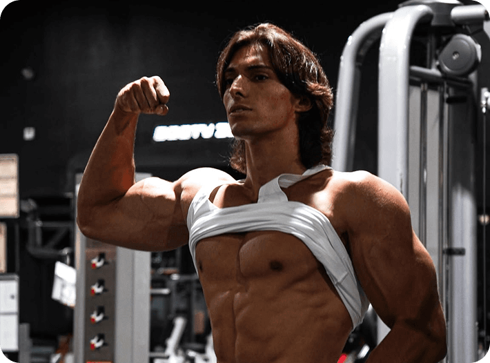 A lifter flexing beside a cable machine in a gym