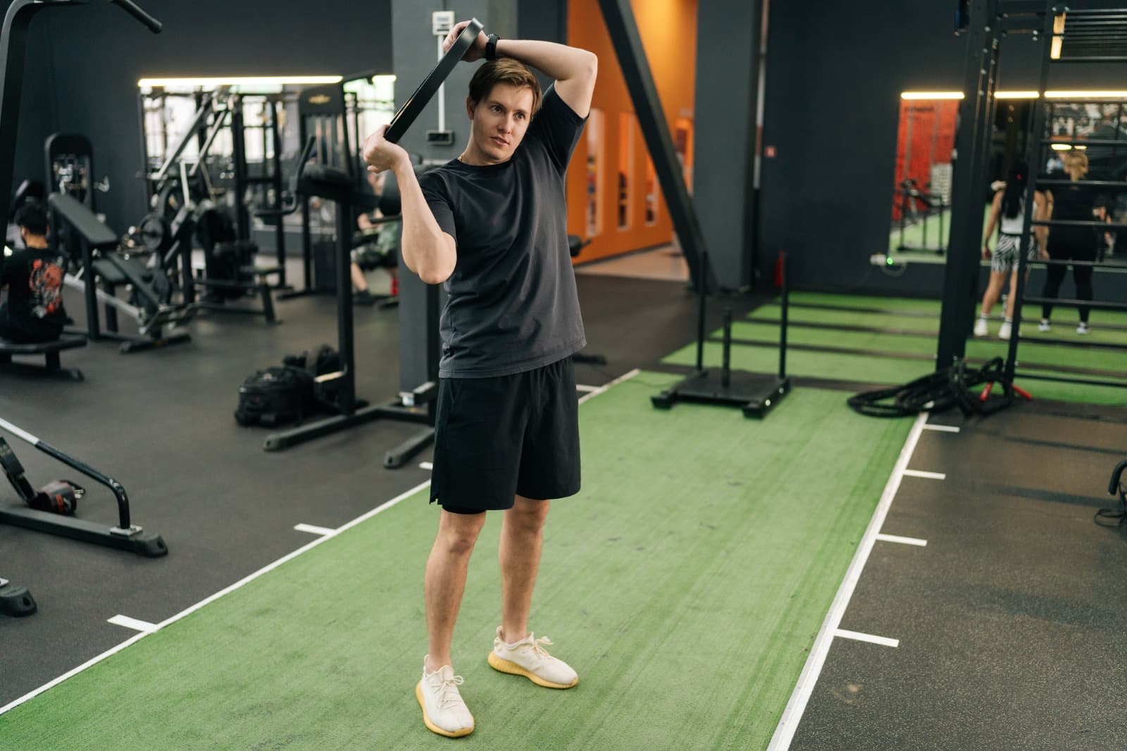 Someone stretching on the turf of a gym floor